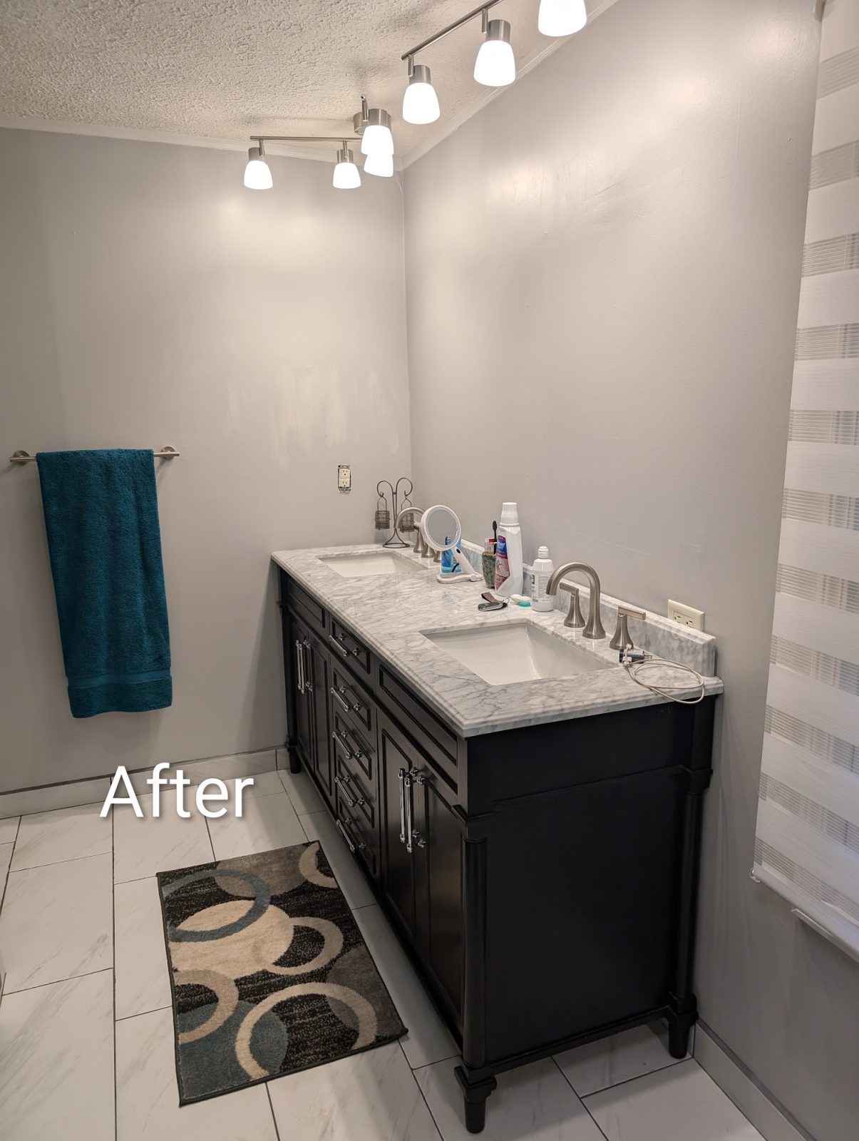 Remodeled bathroom with a double vanity, gray walls and tile floor